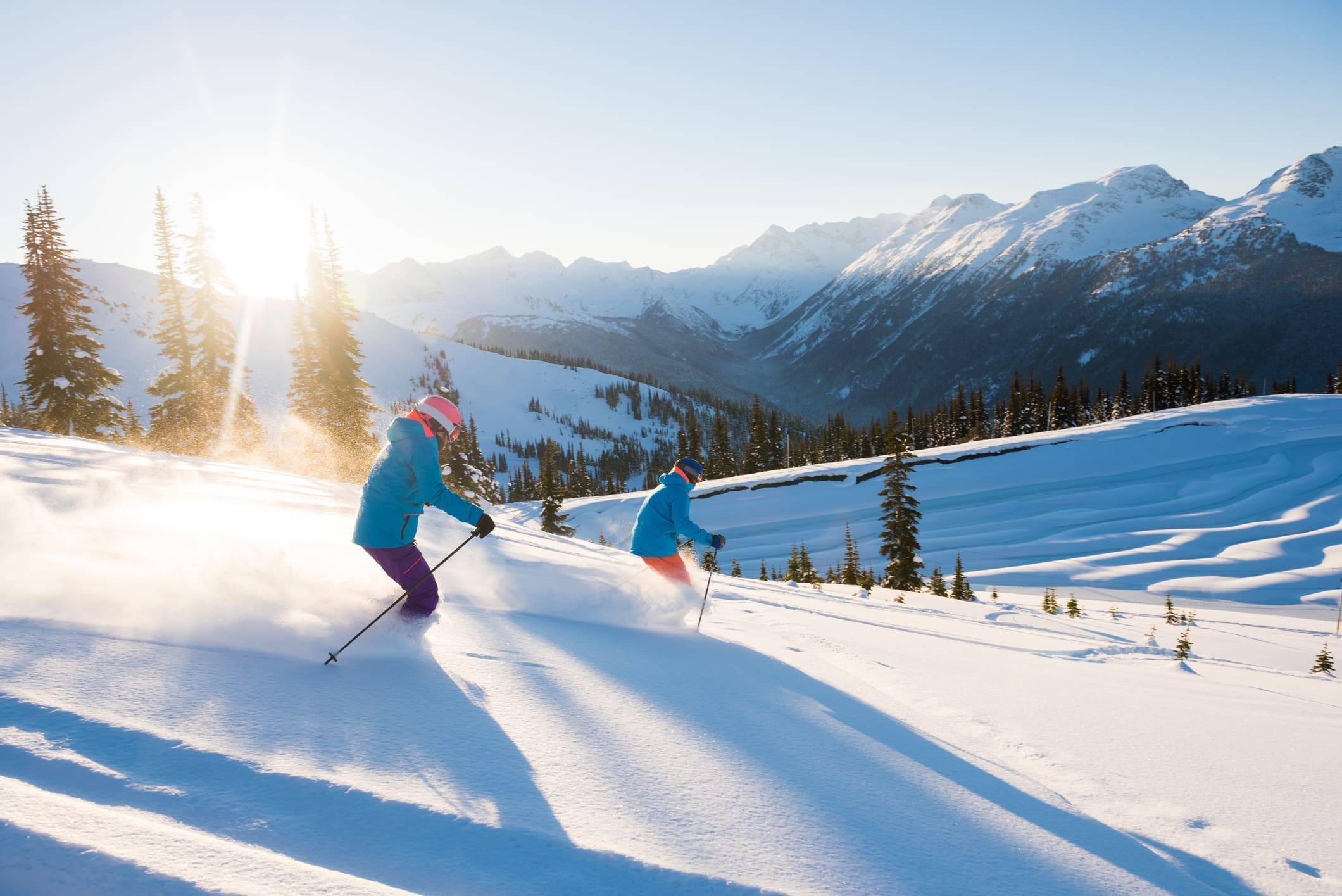 Couple skiing on a sunny powder day black tie ski rentals cover image