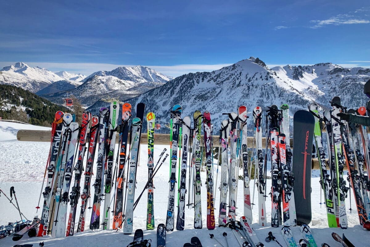 Montgenèvre, France - December 2018: A line of skis and snowboards stored on racks outside a cafe. Ski Resort in the Hautes Alpes buy or rent skis ski rental delivery policies